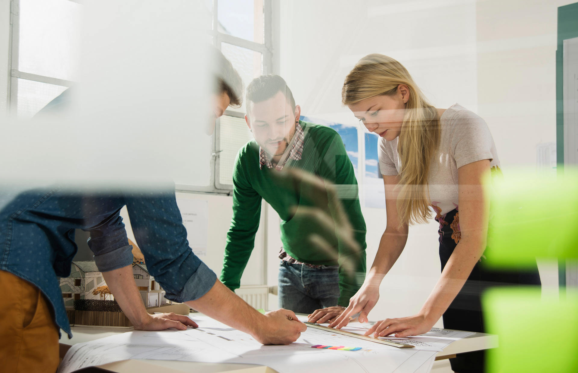 Three young architects in office discussing